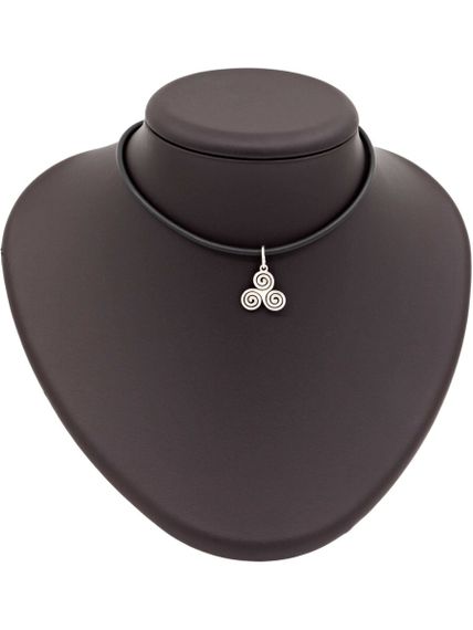 Фото подвески Трискелион из серебра на постаменте.