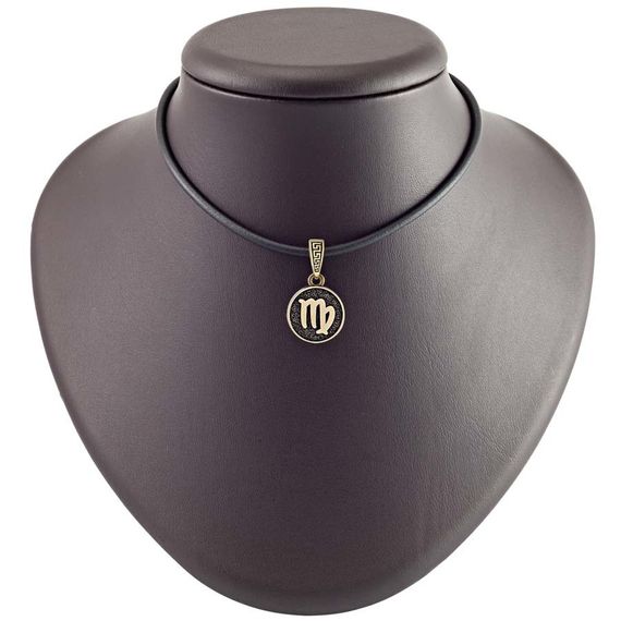 Фото бронзовой подвески знак зодиака Дева на кожаном постаменте.