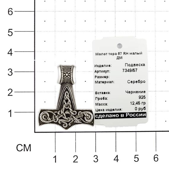 Фотография серебряного молота Тора на размерной сетке.