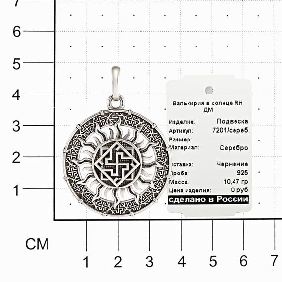 Фотография кулона валькирия в солнце на размерной сетке в масштабе.