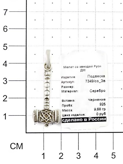 Фотография серебряного молота Сварога со звездой Руси на размерной сетке.