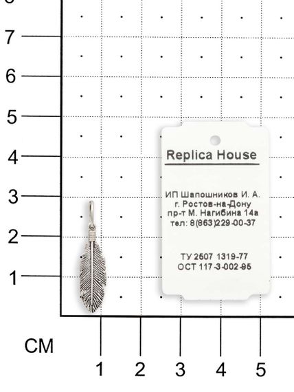 Фото подвески перышко из серебра, вид на размерной сетке.
