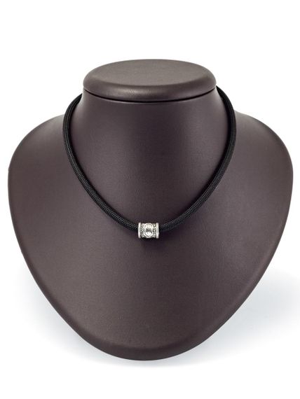 Фотография шарма Хагалаз из серебра 925 пробы на постаменте.