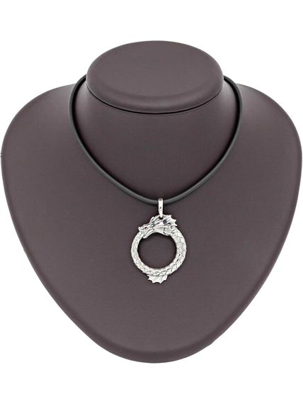 Картинка кулона Уроборос с плавником изготовленного из серебра, вид на коричневом постаменте для масштаба.