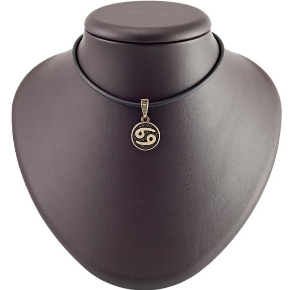 Фотография знака зодиака рак из бронзы на постаменте.