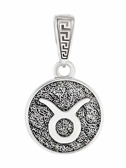 Фотография зодиакального знака Телец из серебра на белом фоне.