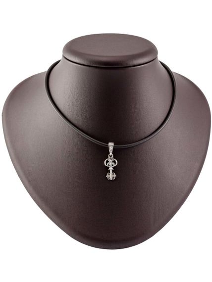 Изображение шарма подвески ключ из серебра 925 пробы, вид на коричневом постаменте в масштабе с кожаным шнурком.